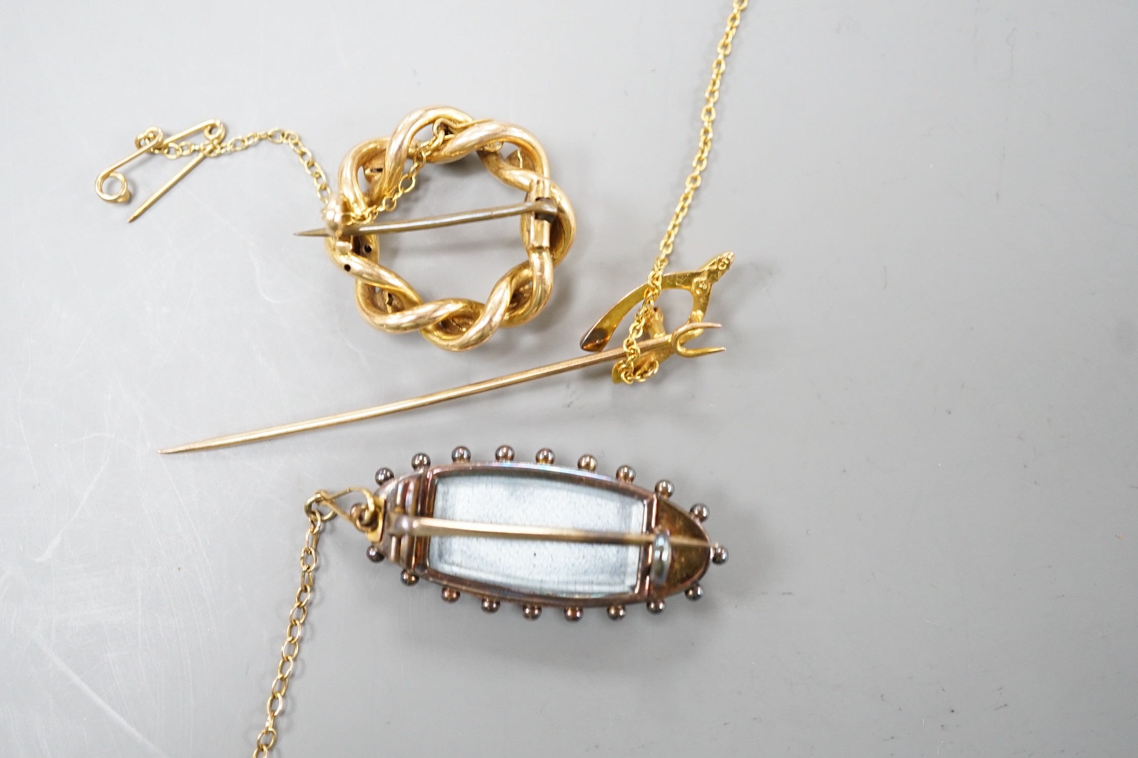 An Edwardian yellow metal, turquoise and split pearl set openwork brooch, 22mm, a similar coral and split pearl set ovoid brooch and a 15ct and gem set wish bone stick pin, gross weight 14.3 grams.